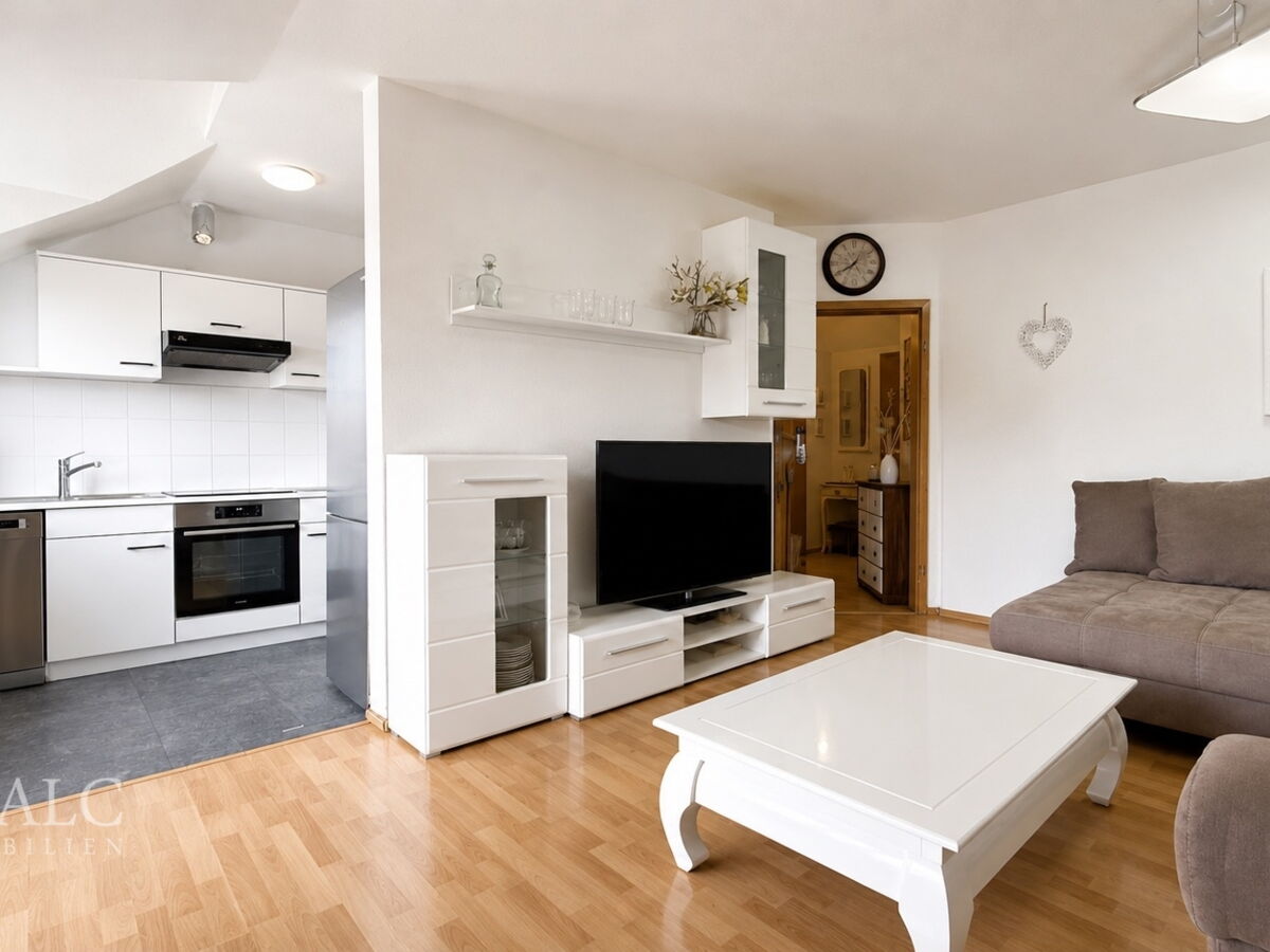 Helles, aufgeräumtes Wohnzimmer mit Küche