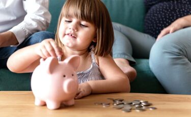 Familie legt Geld in ein Sparschwein